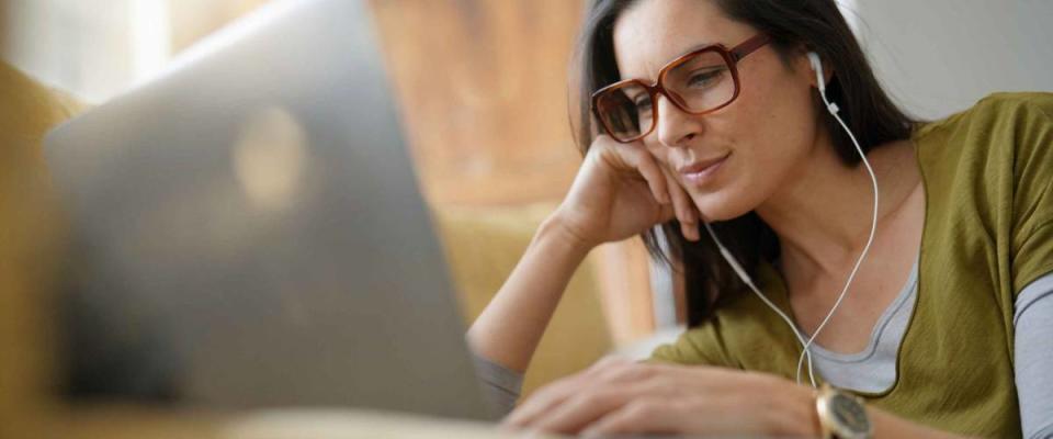 Trendy woman relaxing at home connected with laptop