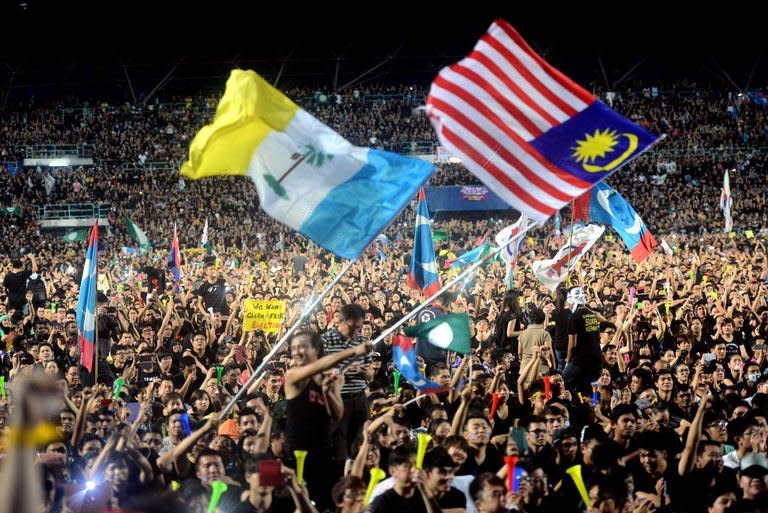 Malaysian opposition party supporters dressed in mourning black wave flags during a rally at a stadium in Kelana Jaya, Selangor on May 8, 2013. Police said Thursday that speakers at a mass rally led by Malaysian opposition leader Anwar Ibrahim to protest against alleged election fraud could face sedition charges