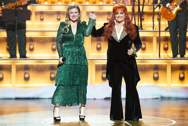 <p>Mickey Bernal/NBC/Getty</p> Kelly Clarkson and Wynonna Judd on Christmas at the Opry