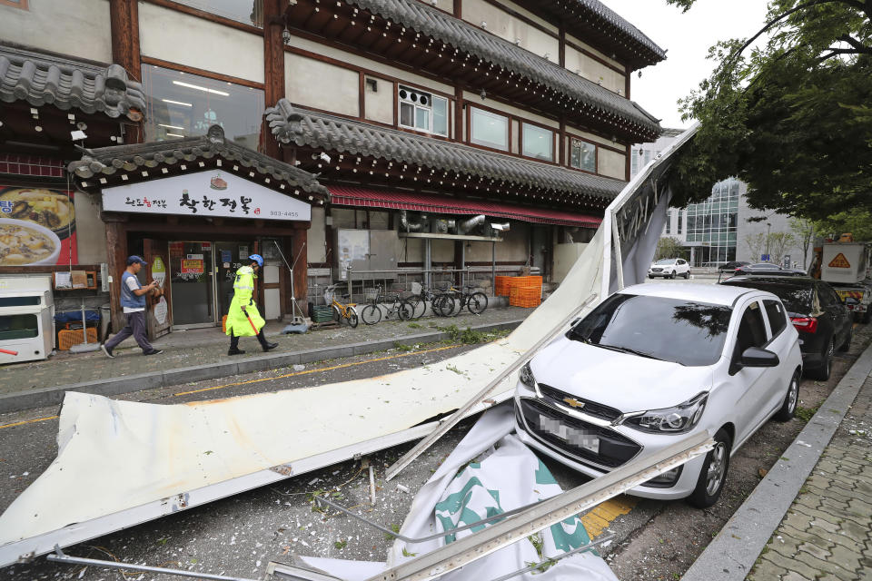 A vehicle is damaged by fallen signboard from a building as Typhoon Lingling brings strong wind and rain in Seoul, South Korea, Saturday, Sept. 7, 2019. The typhoon passed along South Korea's coast Saturday, toppling trees, grounding planes and causing at least two deaths before the storm system made landfall in North Korea. (Ryu Hyung-suck/Yonhap via AP)