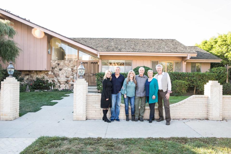 <em>The Brady Bunch</em> actors Maureen McCormick, Christopher Knight, Susan Olsen, Mike Lookinland, Eve Plumb, and Barry Williams pose in front of their TV home. (Photo: HGTV)