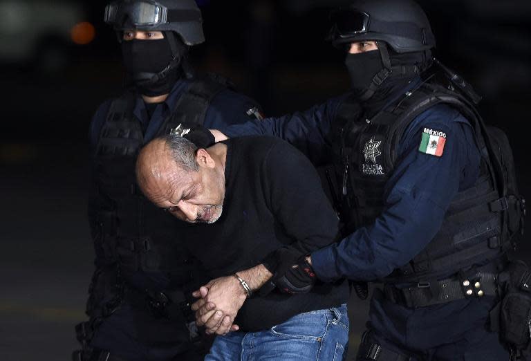 Mexican federal police escort Servando "La Tuta" Gomez from a helicopter upon his arrival at the airport in Mexico City on February 27, 2015