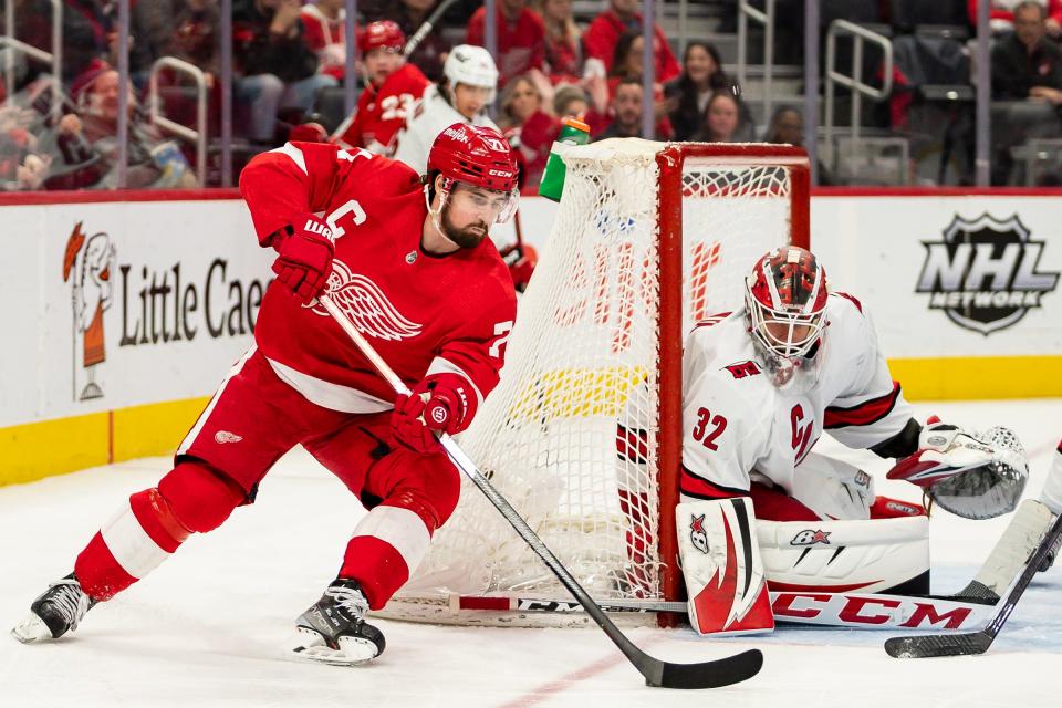 Red Wings center Dylan Larkin tries a backhanded shot against Hurricanes goaltender Antti Raanta during the second period of the Wings' 4-3 overtime win on Tuesday, March 1, 2022, at Little Caesars Arena.