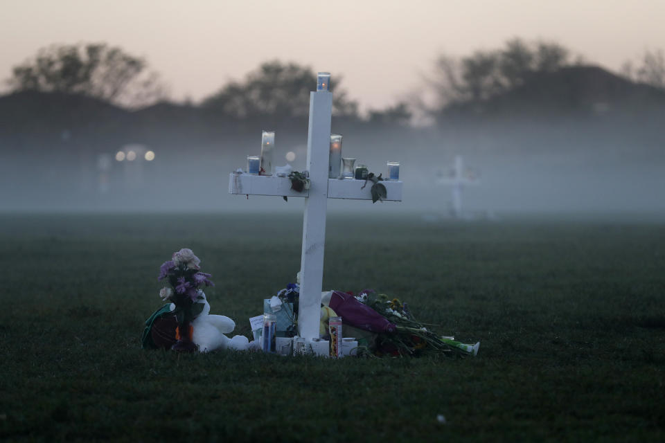 An early morning fog rises where 17 memorial crosses were placed for the 17 students and faculty killed in the shooting at Marjory Stoneman Douglas High School in Parkland, Fla., Feb. 17, 2018. The 2018 Parkland high school massacre will be reenacted with the firing of about 140 blanks on campus as part of families' lawsuits against the former sheriff's deputy they accuse of failing to stop the gunman, a judge ruled Wednesday, July 12, 2023. (AP Photo/Gerald Herbert, File)