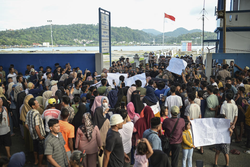 Protesters gather outside a port where a group of Rohingya Muslims have taken shelter since their arrival last month, during a rally in Sabang, Aceh province, Indonesia, Monday, Dec. 18, 2023. More than 200 people have protested against the continued arrival of Rohingya refugees by boat on an island in Indonesia. Over 1,500 Rohingya who fled violent attacks in Myanmar and are leaving camps in Bangladesh have arrived in Aceh off the tip of Sumatra since November. (AP Photo/Reza Saifullah)