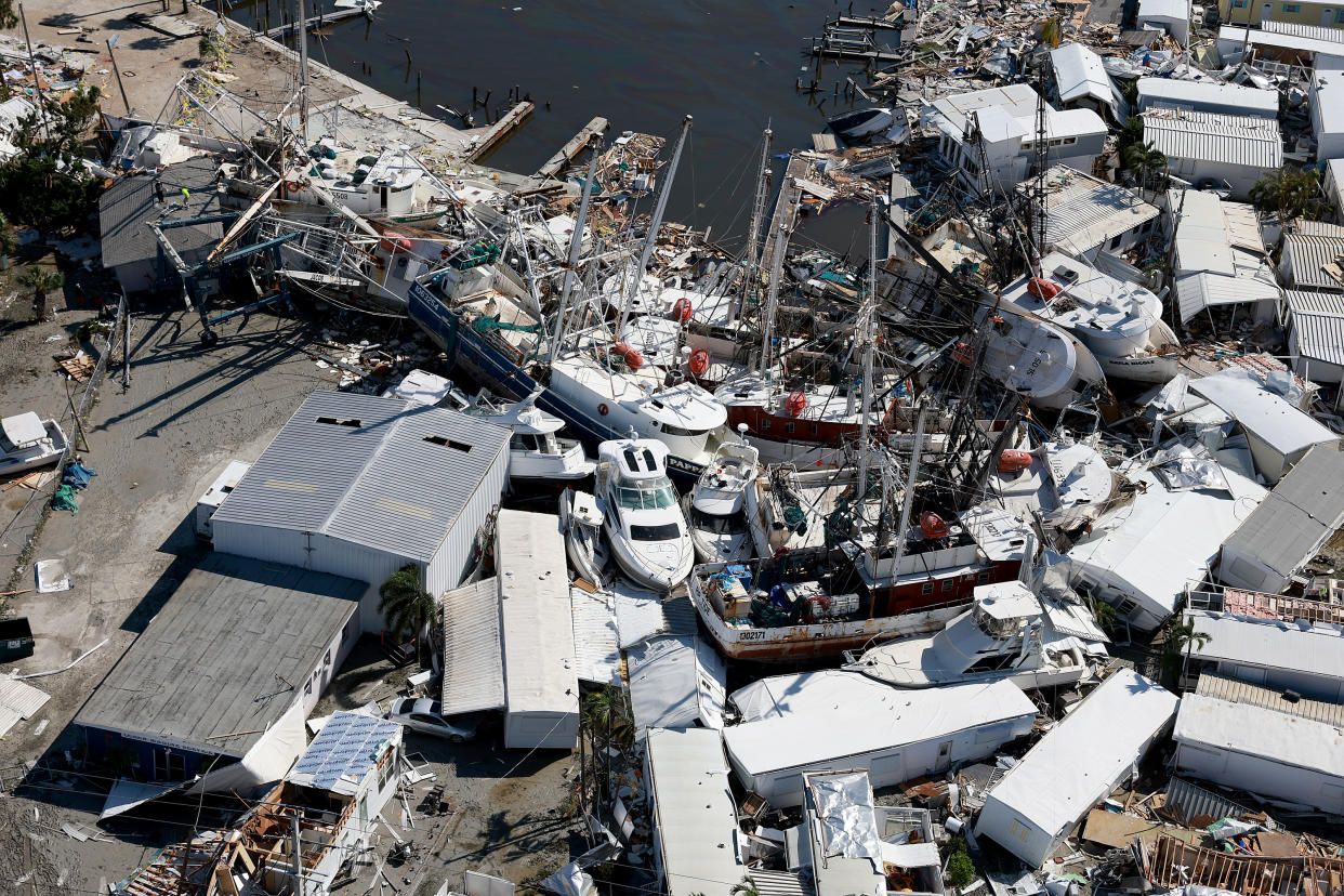 Devastation in a marina, with boats piled on top of each other after being torn from their moorings.