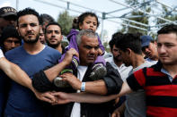 Refugees and migrants wait to welcome Queen Rania of Jordan at the Kara Tepe refugee camp on the island of Lesbos, Greece April 25, 2016. REUTERS/Alkis Konstantinidis