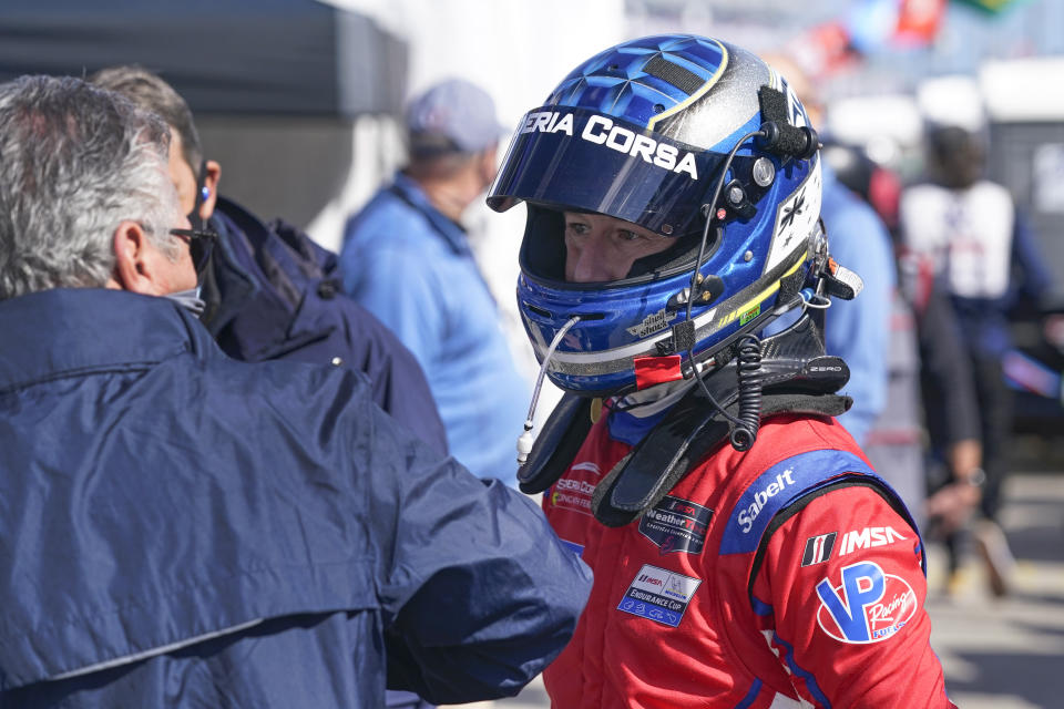 Ryan Briscoe, right, talks with a crew member outside his pit stall during a practice session for the Rolex 24 hour race at Daytona International Speedway, Friday, Jan. 29, 2021, in Daytona Beach, Fla. (AP Photo/John Raoux)