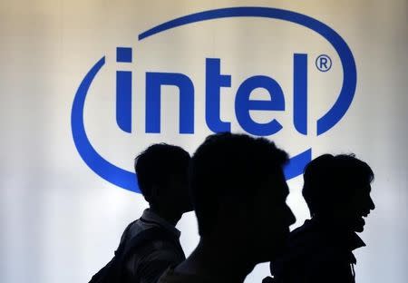 Indonesian youth walk past an Intel sign during Digital Imaging expo in Jakarta March 5, 2014. REUTERS/Beawiharta