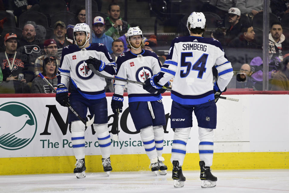 Winnipeg Jets' Kyle Connor, center, celebrates after his goal with teammates Pierre-Luc Dubois and Dylan Samberg (54) during the first period of an NHL hockey game against the Philadelphia Flyers, Sunday, Jan. 22, 2023, in Philadelphia. (AP Photo/Derik Hamilton)