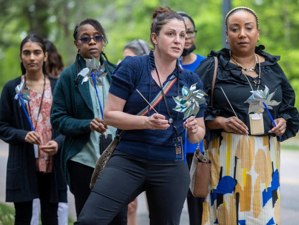 Danielle M. Stipes waits to plant her pinwheel along Departure Drive with others during an observance by the Department of Health and Human Services to raise awareness to child abuse prevention on Wednesday, April 17, 2024 in Raleigh, N.C.