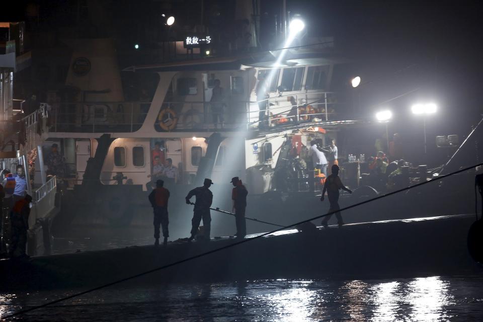 Rescue workers are seen atop the sunken ship in the Jianli section of Yangtze River, Hubei province, China, June 3, 2015. Rescuers fought bad weather on Tuesday as they searched for more than 400 people, many of them elderly Chinese tourists, missing after a cruise boat was buffeted by a freak tornado and capsized on the Yangtze River. (REUTERS/Aly Song)