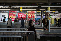 Commuters walk along platforms at a train station Tuesday, April 7, 2020, in Tokyo. Japanese Prime Minister Shinzo Abe declared a state of emergency Tuesday for Tokyo and six other prefectures to ramp up defenses against the spread of the coronavirus. (AP Photo/Jae C. Hong)