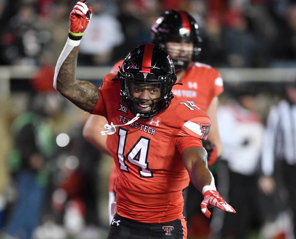 Texas Tech receiver Xavier White (14) celebrates his two-point conversion during the Red Raiders' 51-48 victory Saturday night against Oklahoma. White's score gave Tech a 38-31 lead late in the third quarter.