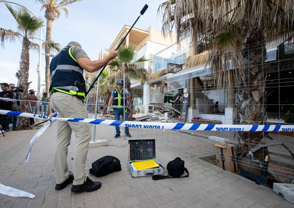 Police officers investigate one day after the two-storey restaurant collapsed (AFP via Getty Images)