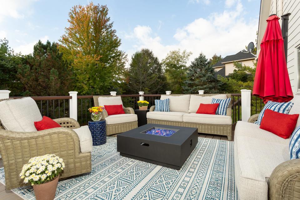 The open-air deck of this Indiana home features furniture with a woven, rattan-like look. The synthetic materials are made for the outdoors, and the upholstery used is made to withstand humidity and major temperature changes.