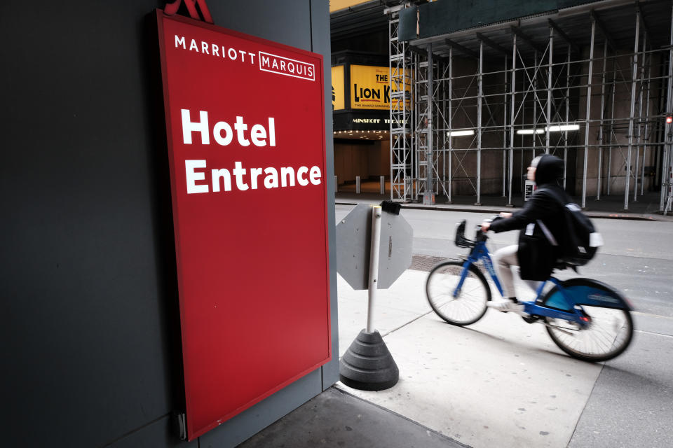 NEW YORK, NY - MARCH 22: A person rides a bike past the Marriott hotel in Times Square as much of the city is void of cars and pedestrians over fears of spreading the coronavirus on March 22, 2020 in New York City. Marriott has announced furlough thousands of workers at its properties throughout the country. Across the country schools, businesses and places of work have either been shut down or are restricting hours of operation as health officials try to slow the spread of COVID-19. (Photo by Spencer Platt/Getty Images)