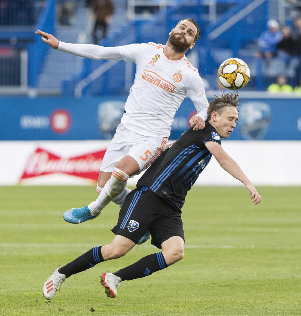 Atlanta United's Leandro Gonzalez Pirez, left, challenges Montreal Impact's Lassi Lappalainen during first half MLS soccer action in Montreal, Sunday, Sept. 29, 2019. (Graham Hughes/The Canadian Press via AP)
