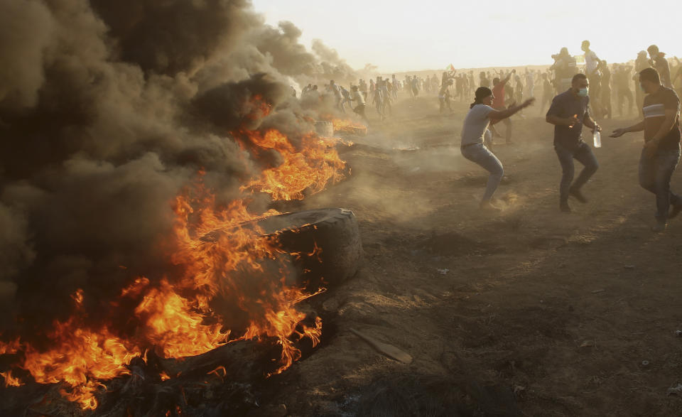 Protesters burn tires while trying to broke the fence of Gaza Strip border with Israel during a protest east of Gaza City, Friday, Sept. 14, 2018. Gaza health officials say 3 Palestinians, including 12-year-old boy, were killed by Israeli army fire in protests along Gaza's perimeter fence. (AP Photo/Adel Hana)