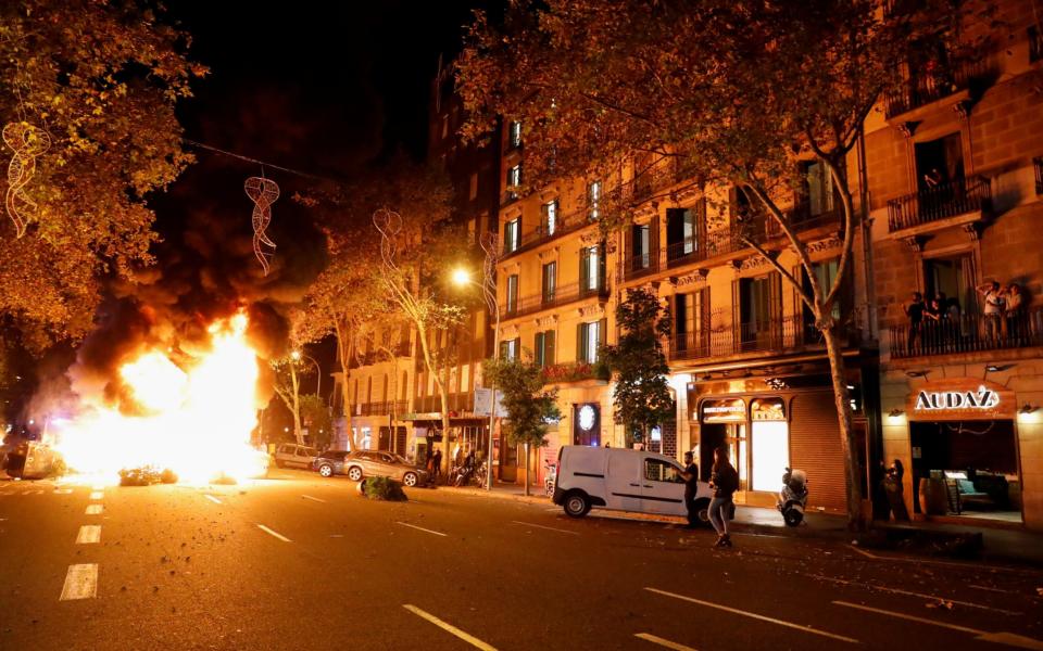 People look at a burning barricade during a protest  - REUTERS