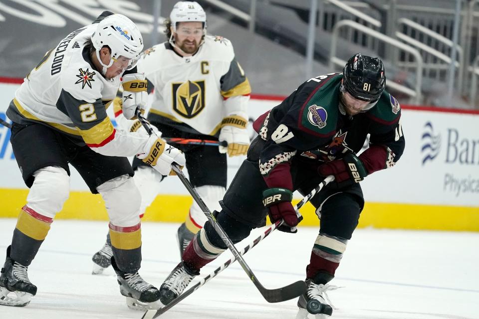 Vegas Golden Knights defenseman Zach Whitecloud (2) bounces the puck off the skate of Arizona Coyotes right wing Phil Kessel (81) as Golden Knights right wing Mark Stone, center, looks on during the third period of an NHL hockey game Friday, Jan. 22, 2021, in Glendale, Ariz. (AP Photo/Ross D. Franklin)