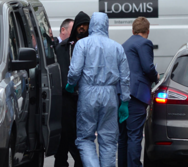 Forensics experts and police stand with a man where the knives were found (PA)