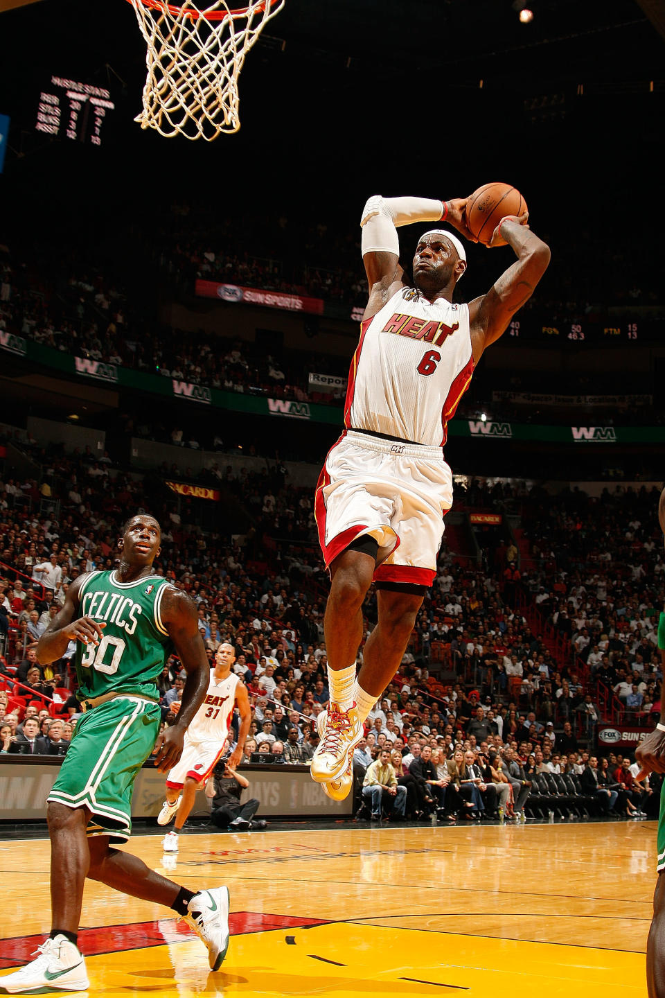 MIAMI, FL - OCTOBER 30: LeBron James #6 of the Miami Heat dunks against Brandon Bass #30 of the Boston Celtics during the NBA game on October 30, 2012 at American Airlines Arena in Miami, Florida. NOTE TO USER: User expressly acknowledges and agrees that, by downloading and/or using this photograph, user is consenting to the terms and conditions of the Getty Images License Agreement. Mandatory copyright notice: Copyright NBAE 2012 (Photo by Issac Baldizon/NBAE via Getty Images)