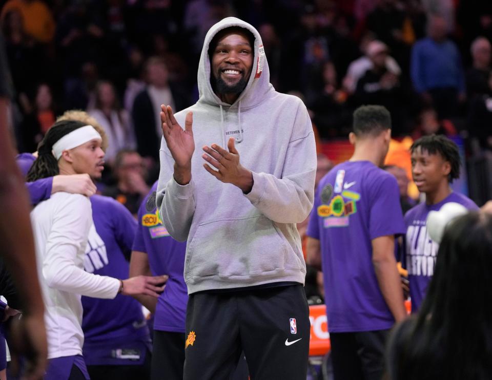Phoenix Suns forward Kevin Durant claps for his new teammates during the first quarter against the Sacramento Kings at Footprint Center in Phoenix on Feb. 14, 2023.