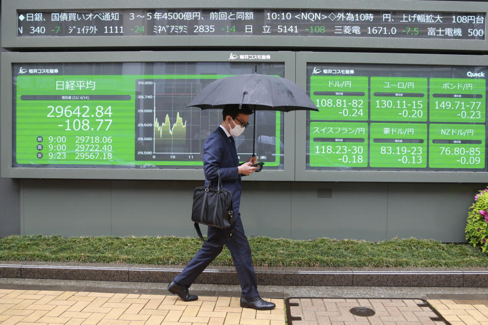 A man walks by an electronic stock board of a securities firm in Tokyo, Wednesday, April 14, 2021. Asian stock markets rose Wednesday after Wall Street hit a high following an uptick in U.S. inflation and an order by regulators to suspend use of Johnson & Johnson's coronavirus vaccine. (AP Photo/Koji Sasahara)