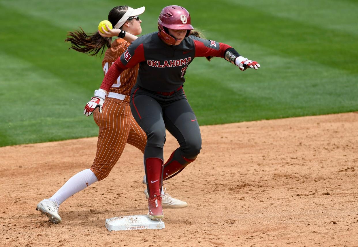 Texas’ Leighann Goode (43) throws the ball to first base as OU's Kasidi Pickering (7) reaches second on Sunday in Austin, Texas.