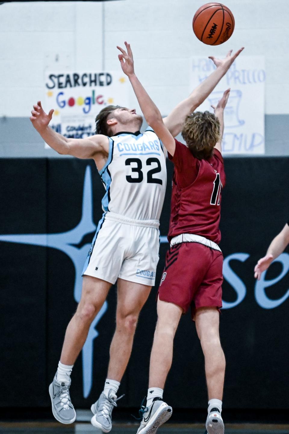 Lansing Catholic's Alex Watters, left, and Portland's Dom Novara battle for a rebound in the first half on Friday, Jan. 14, 2022, at Lansing Catholic High School in Lansing.