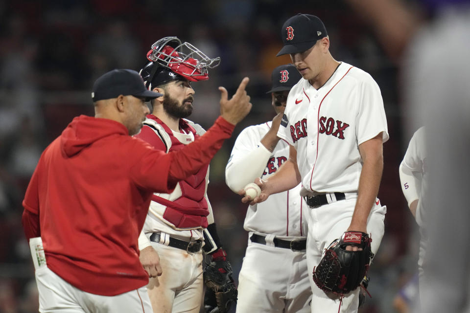 Boston Red Sox pitcher Nick Pivetta, right, is pulled by manager Alex Cora, left, after giving up a bases-loaded walk to Colorado Rockies' Randal Grichuk with the score tied in the top of the 10th inning during a baseball game at Fenway Park, Monday, June 12, 2023, in Boston. (AP Photo/Charles Krupa)