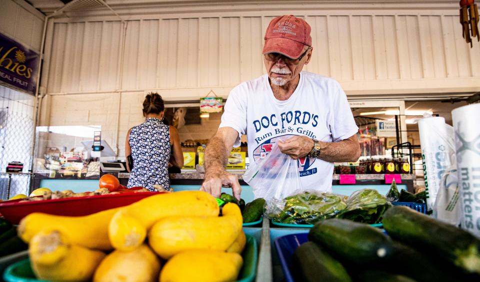 Cape Coral resident Joe Biela grabs some produce at Tropicaya Fresh Produce on Pine Island Road.