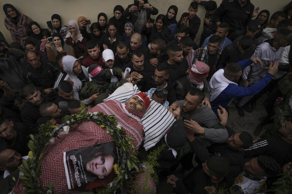 Palestinian mourners carry the body of Omar Manaa during his funeral in the West Bank refugee camp of Deheishe near Bethlehem, Monday, Dec. 5, 2022. Palestinian health officials say Manaa, a 22-year-old Palestinian man, was killed by Israeli fire during a military raid in the occupied West Bank. The army said it opened fire after a crowd attacked soldiers with stones and firebombs. (AP Photo/Mahmoud Illean)