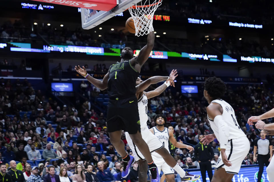 New Orleans Pelicans forward Zion Williamson (1) goes to the basket in front of Brooklyn Nets forward Royce O'Neale (00) in the second half of an NBA basketball game in New Orleans, Tuesday, Jan. 2, 2024. The Pelicans won 112-85. (AP Photo/Gerald Herbert)