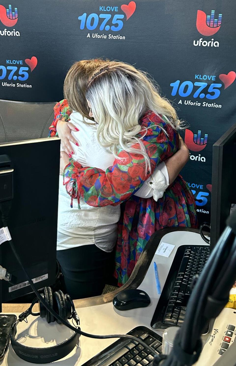 María Elena Nava, left, and Denise Reyes hug after finishing their first day on air together at KLVE.