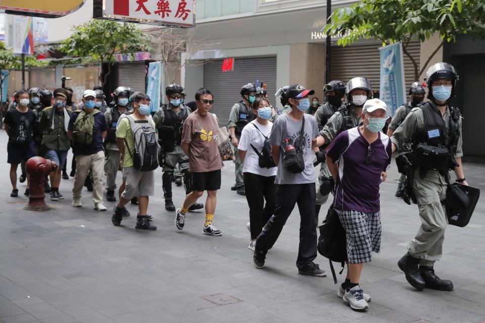 Police detain protesters after a protest in Causeway Bay before the annual handover march in Hong Kon