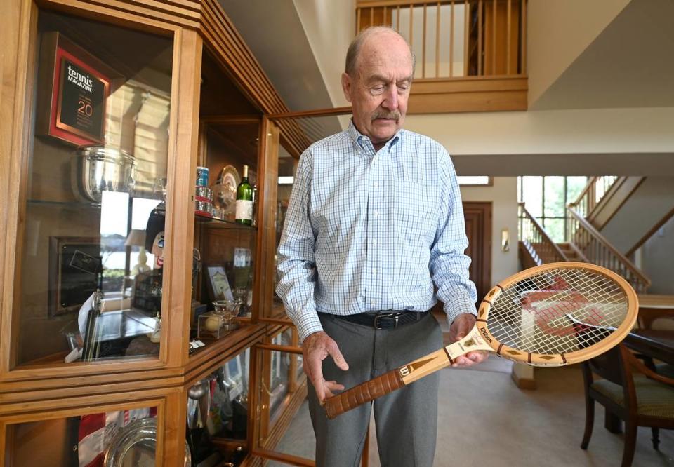 Former professional tennis player Stan Smith looks at the wooden racket he used in tournament play on Monday, March 11, 2024. Smith won the 1971 US Open and the 1972 Wimbledon Championships. He was ranked No. 1 in the world in 1972.