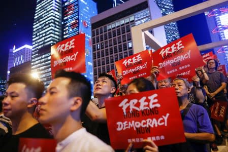 Demonstrators hold placards during a rally ahead of the G20 summit, urging the international community to back their demands for the government to withdraw a the extradition bill in Hong Kong