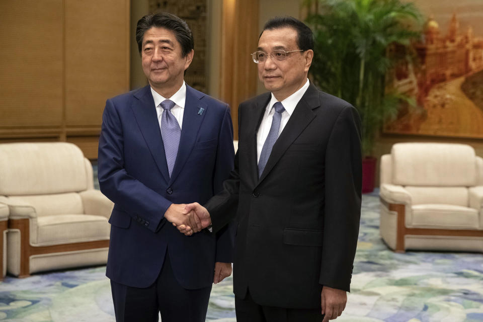 Chinese Premier Li Keqiang, right, and Japanese Prime Minister Shinzo Abe shake hands during their meeting at the Great Hall of the People in Beijing, Thursday, Oct. 25, 2018. Abe arrived in Beijing on Thursday as both countries try to repair ties that have been riven by disputes over territory, military expansion in the Pacific and World War II history. (Roman Pilipey/Pool Photo via AP)