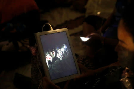 A family member looks at a photo near Tham Luang cave complex, as members of under-16 soccer team and their coach have been found alive according to a local media's report in the northern province of Chiang Rai, Thailand, July 2, 2018. REUTERS/Soe Zeya Tun