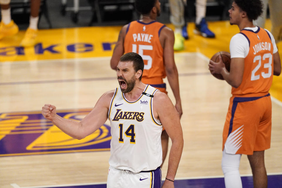 Los Angeles Lakers center Marc Gasol, left, celebrates after scoring as Phoenix Suns guard Cameron Payne, center, and forward Cameron Johnson stand in the background during the first half in Game 4 of an NBA basketball first-round playoff series Sunday, May 30, 2021, in Los Angeles. (AP Photo/Mark J. Terrill)