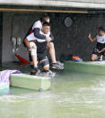 Japan's rugby team player Jiwon Koo, carries teammate James Moore in a flooded walkway at a stadium in Tokyo as the team practices ahead of their match against Scotland, Saturday, Oct. 12, 2019. Tokyo and surrounding areas braced for a powerful typhoon forecast as the worst in six decades, with streets and trains stations unusually quiet Saturday as rain poured over the city. (Yuki Sato/Kyodo News via AP)