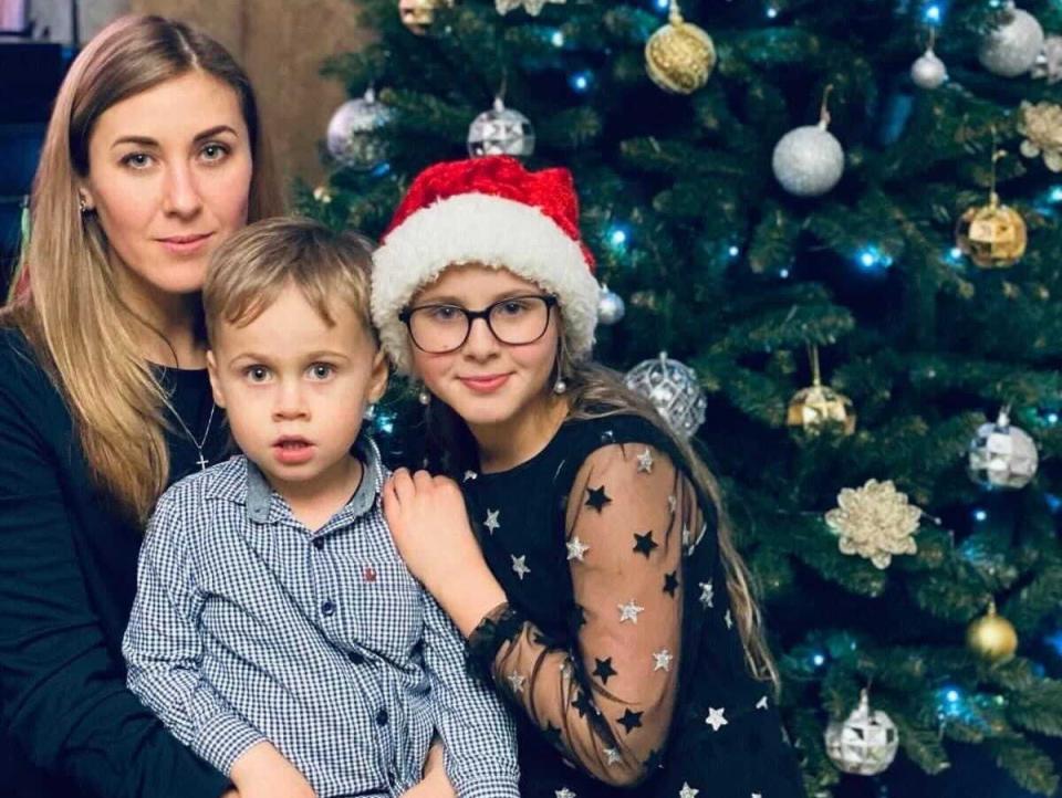 Natalia, Luka, and Mariia pose for a Christmas photo