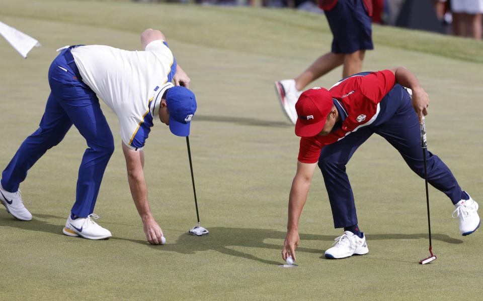 Europe team's Rory McIlroy of Northern Ireland (L) and the US team's Xander Schauffele - Shutterstock