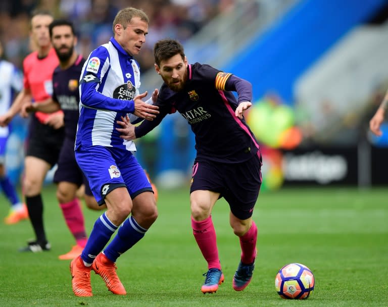 Deportivo La Coruna's midfielder Alex Bergantinos (L) vies with Barcelona's Argentinian forward Lionel Messi during the Spanish league football match at the Municipal de Riazor stadium in La Coruna on March 12, 2017