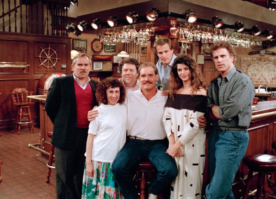 Boston Red Sox third baseman Wade Boggs, center, poses, March 2, 1988, with the cast of the television comedy series “Cheers” during a break in rehearsal for an upcoming episode in which Boggs has a cameo appearance. Cast members include, left to right: John Ratzenberger, Rhea Perlman, George Wendt, Boggs, Woody Harrelson, Kirstie Alley and Ted Danson. (AP Photo/Ira Mark Gostin)