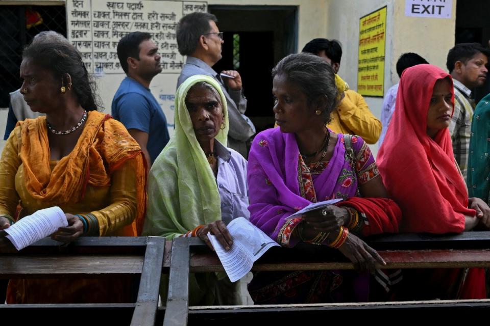 People stand in a queue to cast their votes at a polling station in Haridwar in the northern Uttarakhand state on 19 April 2024 (AFP via Getty Images)