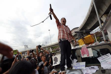 A woman gestures from atop a vandalized army vehicle during a brief confrontation between anti-coup protesters and soldiers at the Victory monument in Bangkok May 28, 2014. REUTERS/Damir Sagolj