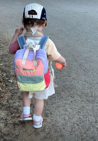 <p>Olivia Munn/Instagram</p> Olivia Munn's son Malcolm walks while carrying a personalized backpack.